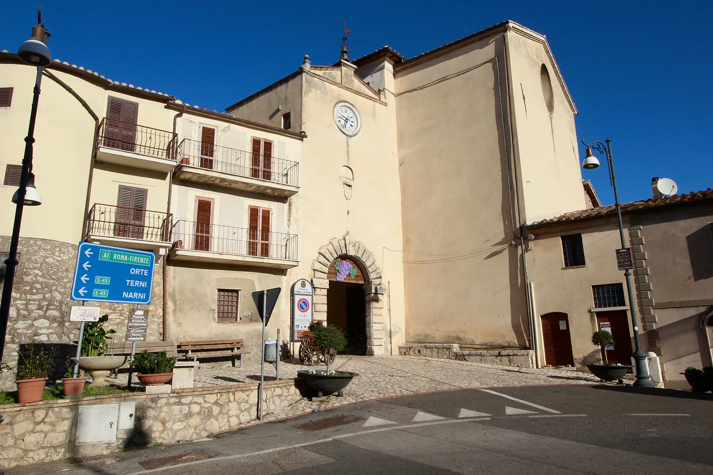 Sunlit stone gateway and square at Porta Civica in Penna in Teverina